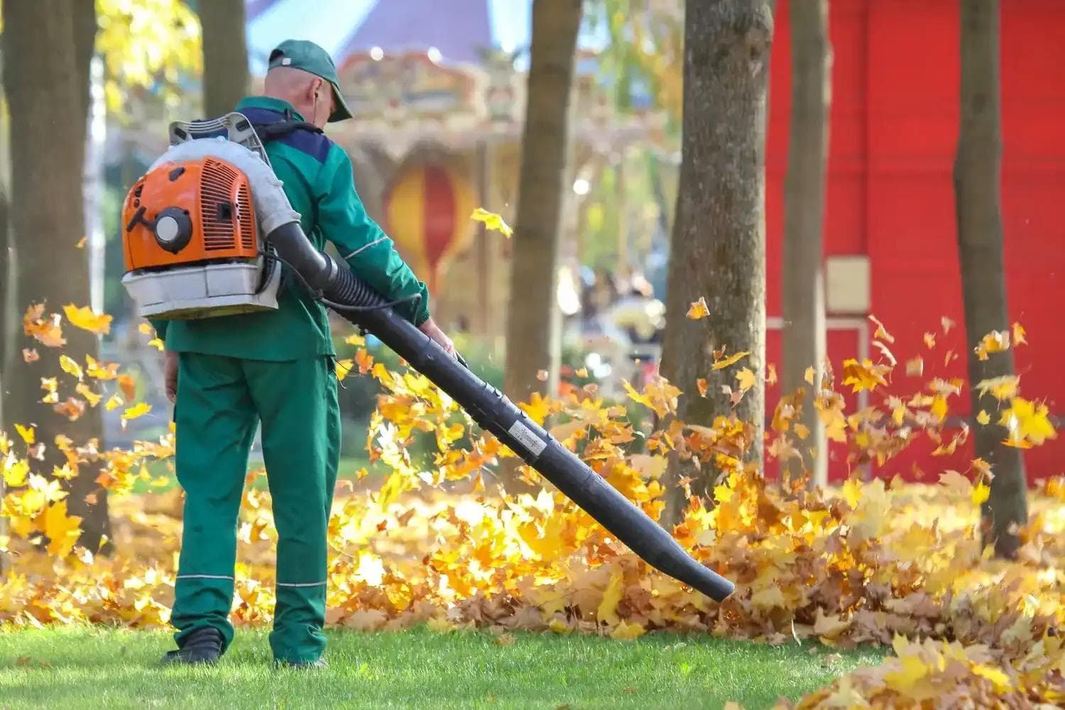 Landscaper using a powerful leaf blower to clear autumn leaves, offering efficient yard care services in Central Oregon.